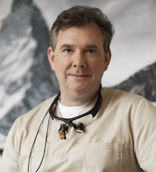 Portrait Dr. Max Heuermann vor Hintergrund mit Bergen