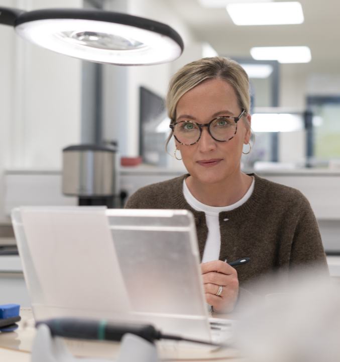 Unsere Labormitarbeiterin färbt einen Zahnersatz